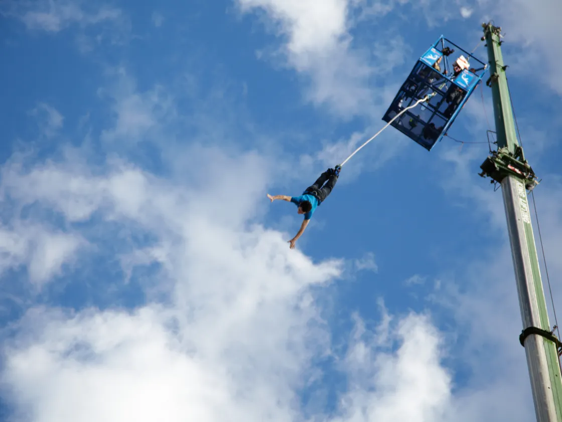 a person leaps through the air in a bungee jump