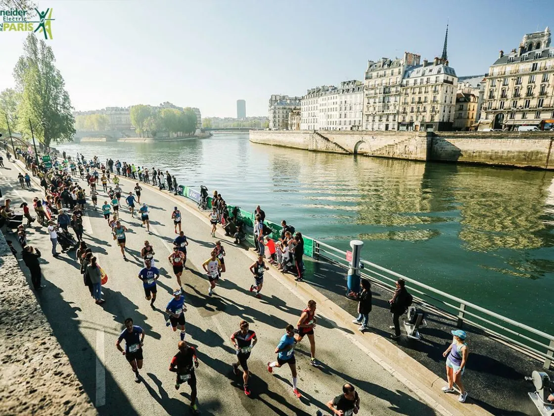 Runners run past the Seine