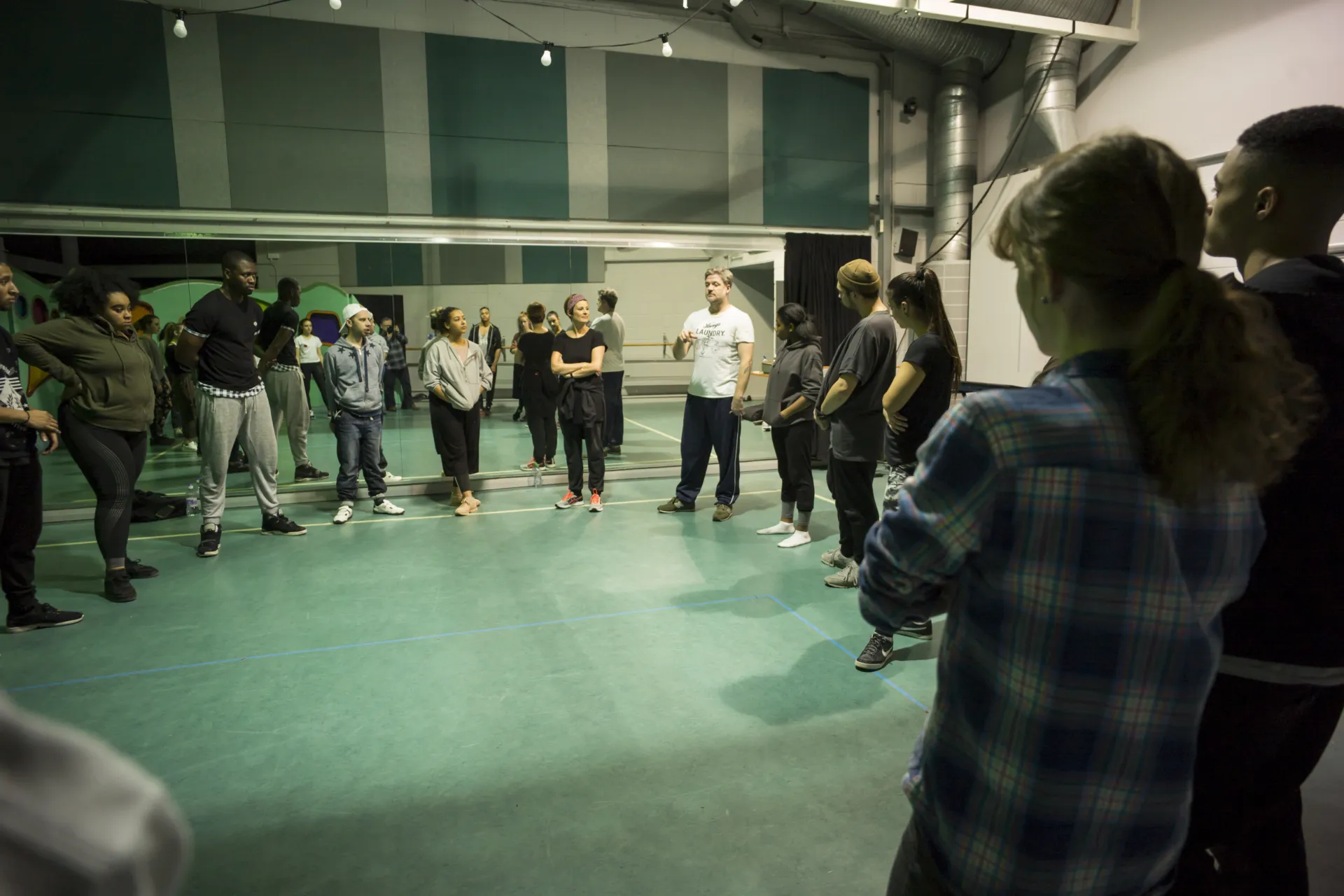a group standing in a circle smiling and talking.