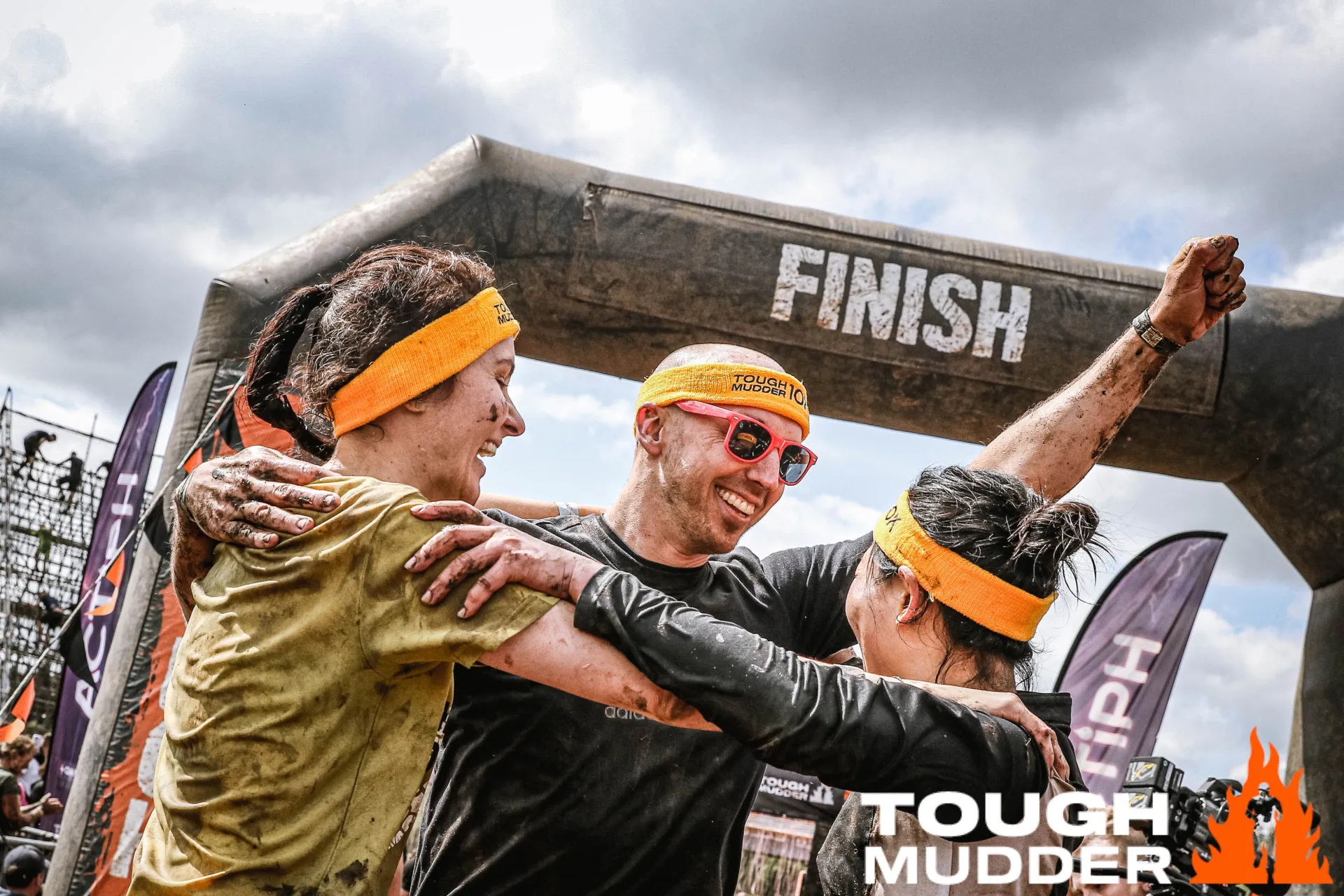 three people celebrate at Tough Mudder