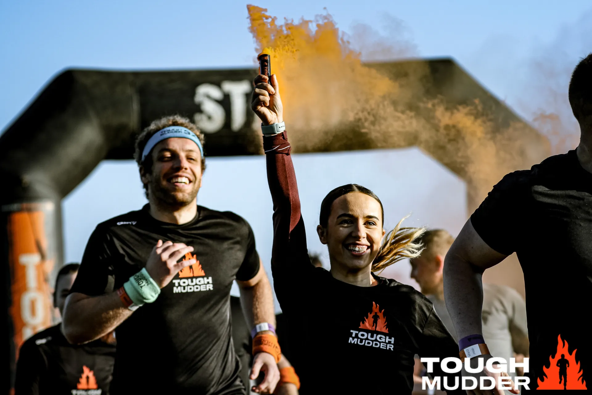 A woman holds a flare at Tough Mudder