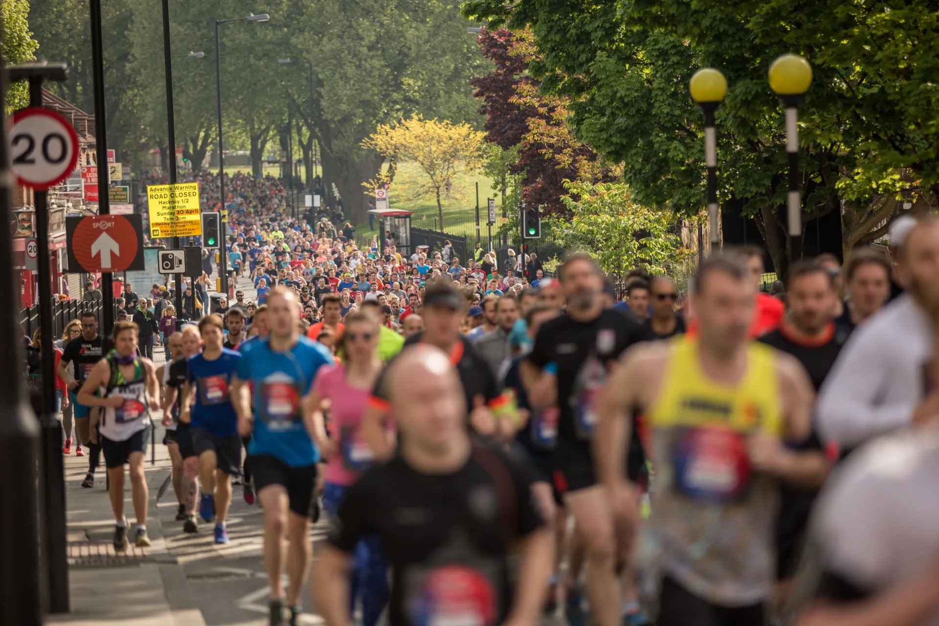 Lots of runners running through a park at the Hackney Half Marathon
