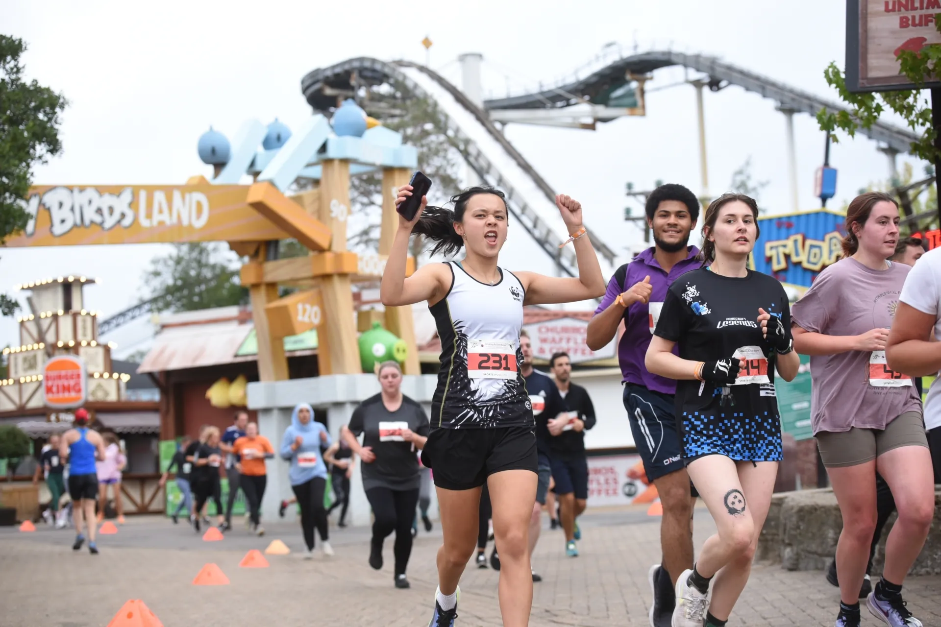 runners at the Run Thorpe Park event with a rollercoaster in the background