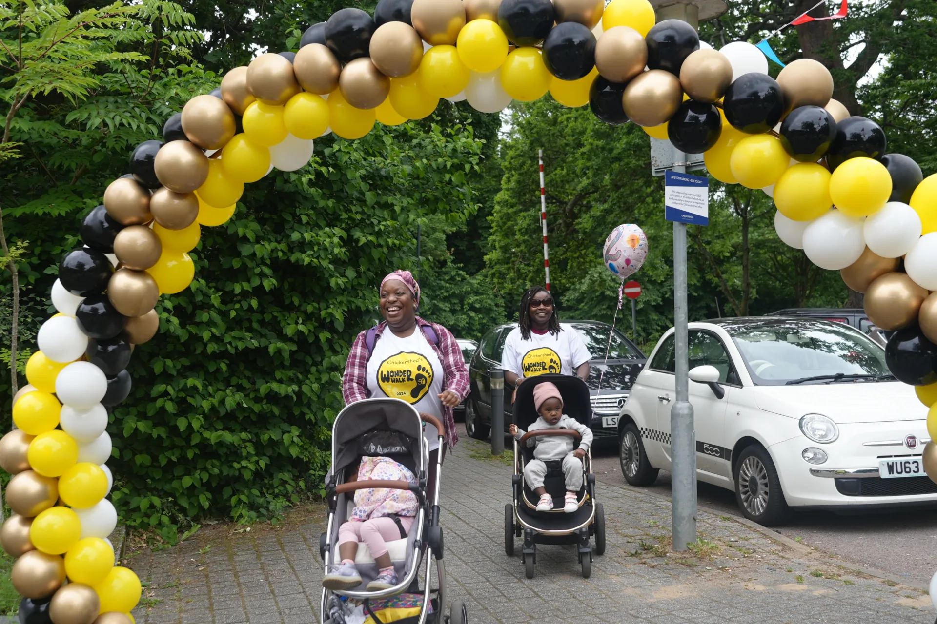 2 Woman crossing the finish line with 2 children in buggies