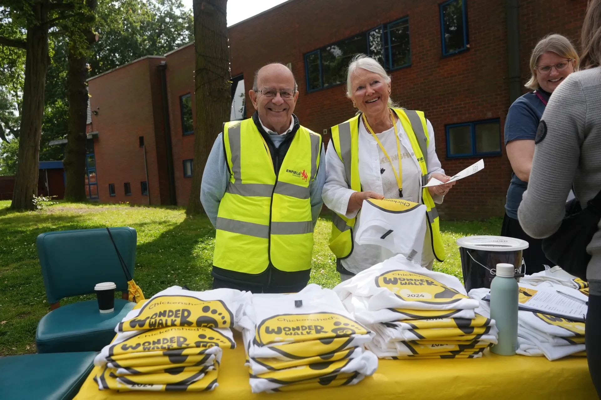 2 volunteers handing out T-shirts