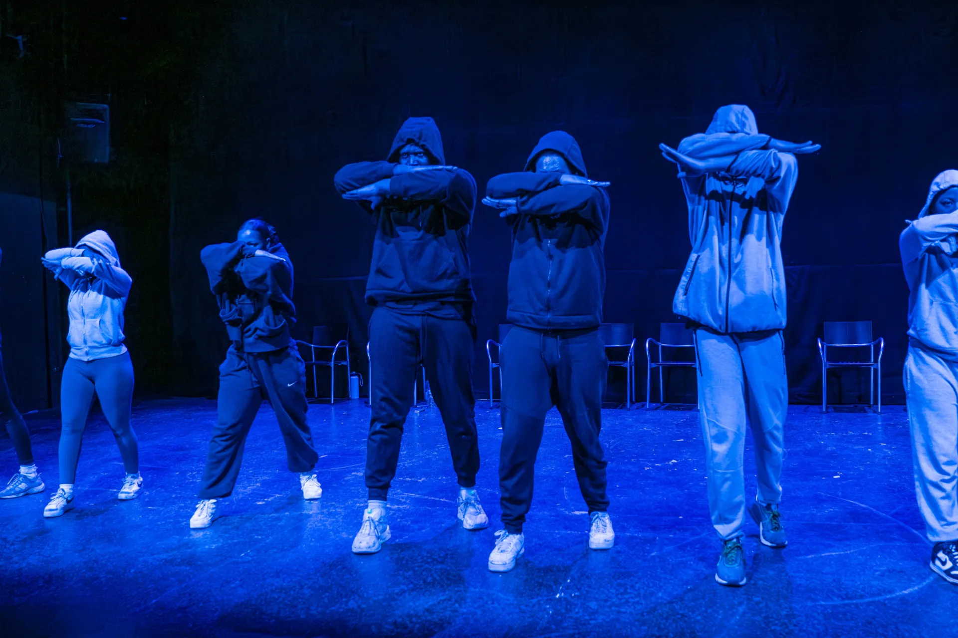 crime cast in a line with their heads down and hands up folded